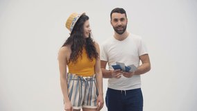 4k slowmotion video of cheerful young couple with passports and tickets over white background.