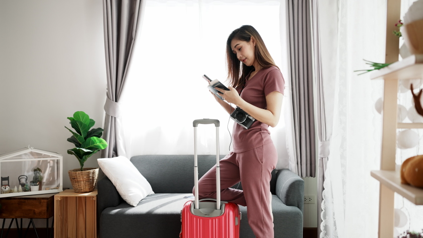 Attractive Asian woman with travel baggage have using smartphone booking flight tickets in online website and Purchase, Pay by credit card. Woman success booking travel tickets in promotion time. | Shutterstock HD Video #1064653525