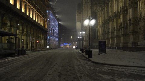 Europe, Italy , Milan 28 December 2020 - night snowfall in downtown during Covid-19 Coronavirus Christmas lockdown - Snow in Duomo cathedral and Vittorio Emanuele gallery
