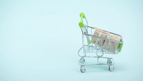 Cropped view of man hanging label on shopping cart on blue background