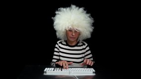 Grandma with white afro hair typing on keyboard and concentrating