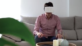 Authentic shot of young millennial man wearing vr headset at home - Virtual reality technology concept - Powered by Shutterstock - Get 15% off with code: PIKWIZARD15
