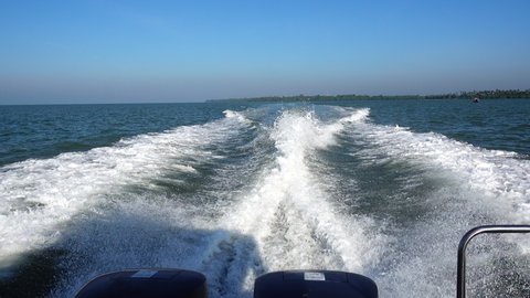 Ship wake on the ocean.aves from the back of a speed boat over the water's surface in sea. Waves behind a boat on a clear blue sea