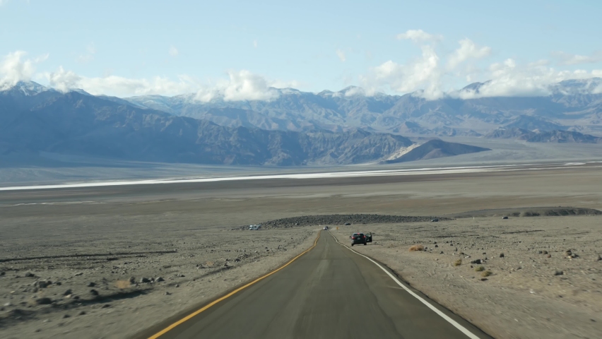 Road trip to Death Valley, Artists Palette drive, California USA. Hitchhiking auto traveling in America. Highway, colorful bare mountains and arid climate wilderness. View from car. Journey to Nevada.