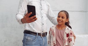 Slow-motion handheld portrait of father with daughter taking making selfie photo video on mobile smart phone digital device camera pov