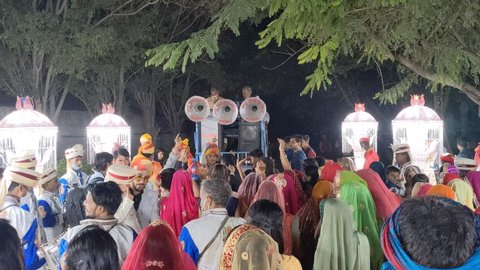 Jaipur, Rajasthan, India - Dec 2020: Wedding guests dancing in the street during hindu indian wedding with Band Baja