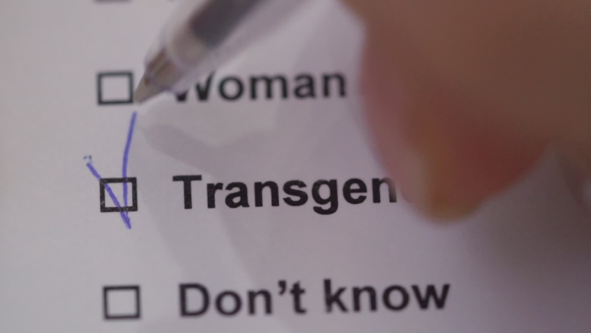 A person puts a tick in front of the word Transgender in the test. Close-up. Indicating your gender | Shutterstock HD Video #1064713726