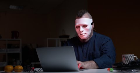A man in an incognito mask shows two middle fingers to the camera. Computer cracker. Hacker. Fuck you