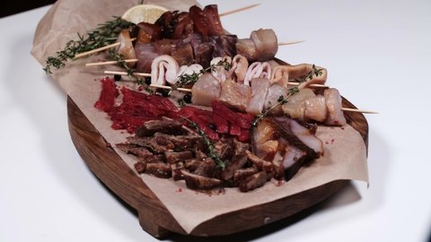 snacks from different types of fish to beer. pieces of smoked fish, squid, fish plate. Rotates on a plate. Cyclic motion