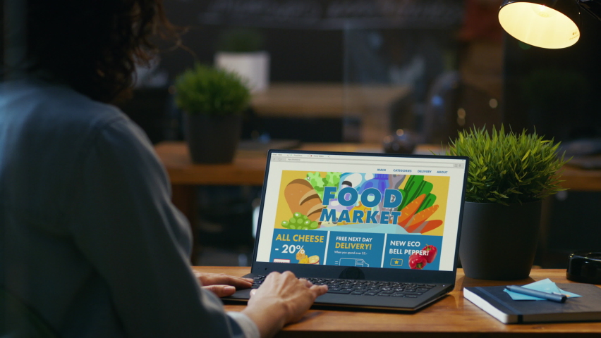 Person Uses Laptop Computer Browsing through Online Food Delivery Market, Choosing Through Vegetables Section, Fresh Goods. Internet Store Software with List of Food to Order. Over The Shoulder Royalty-Free Stock Footage #1064722507
