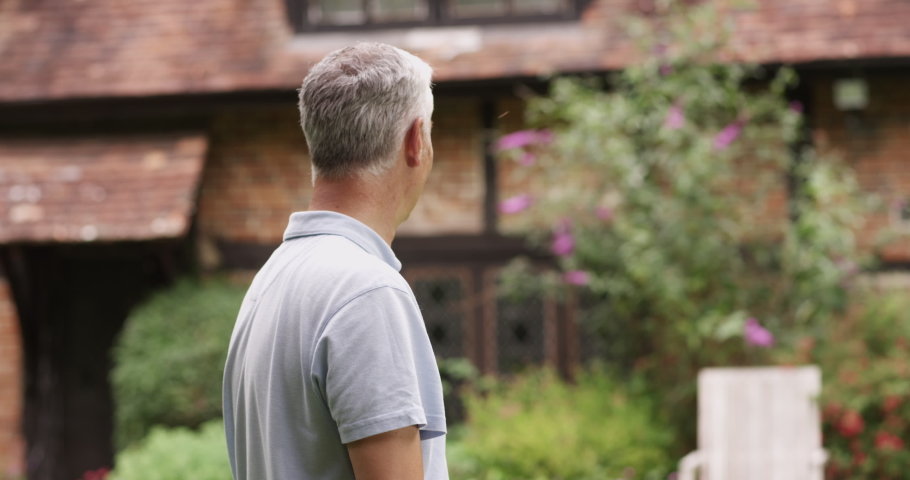 4k, Proud retired man standing outside his house looking at camera and smiling