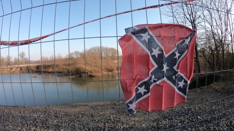 Rebel flag on the fence flying in the wind.