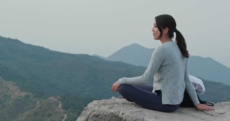 Woman sit on the top of the mountain