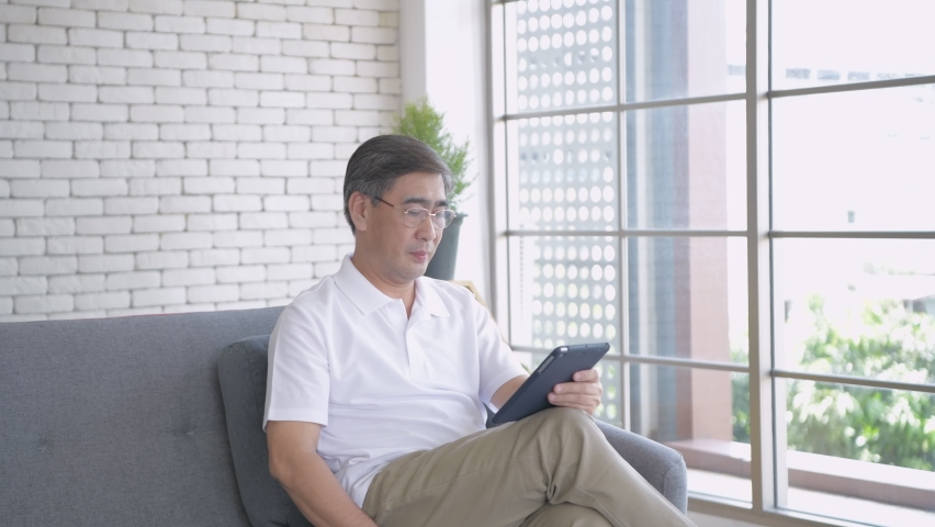 Health concept of 4k Resolution. A middle-aged Asian man is suffering from eye strain due to his long-time looking at the tablet. Royalty-Free Stock Footage #1064736970