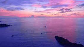 Aerial view Drone camera video of Sunset over sea with tourist boats to see Beautiful sunset sky Landscape nature view at Laem Promthep cape Phuket Thailand Amazing light nature in golden hour sky