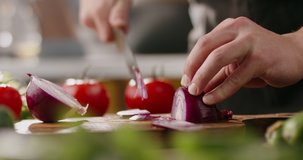 Chef using a knife cutting fresh raw onions. Cooker at home making a healthy vegetable meal, cutting up veggies - food and drink 4k footage