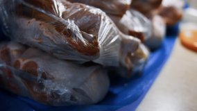 Close-up view of packed chicken legs into individual plastic bags. Process of freezing meat for further use at home. 4K video
