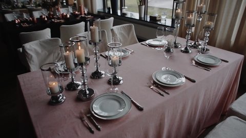 Glasses and plates on a banquet table. Night Party at a fancy restaurant. Festive time, celebration event on holidays. Beautiful decoration on tables. 