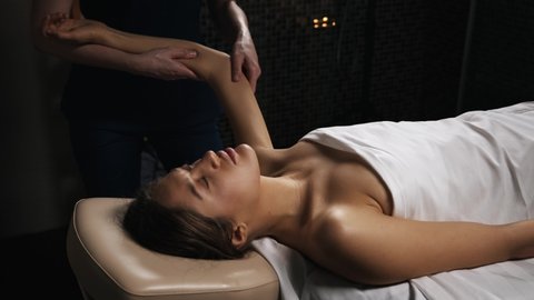 Young beautiful woman gets body massage in spa salon. Naked lady perfect skin.