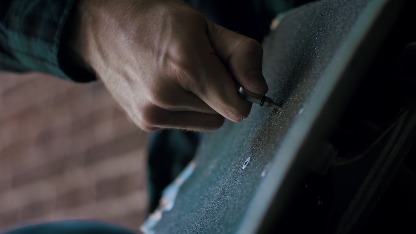 Man unscrewing a screw on his skateboard | Shutterstock HD Video #1064775439