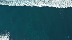 Beautiful background screen saver video of surfing wave roll over quiet waters. Surf with white foam swirls washing over ocean or sea shore. High or low tide, surfers waiting for perfect wave