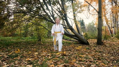 teenager girl 12 years old is engaged in karate outdoors in the park. Healthy lifestyle concept. playing sports. martial arts. Judo, Jiujitsu. brave, strong