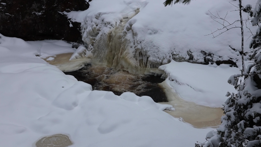 Frozen over Amnicon River and waterfalls with fresh snow during winter with sound at Amnicon Falls State Park in Douglas County Wisconsin
