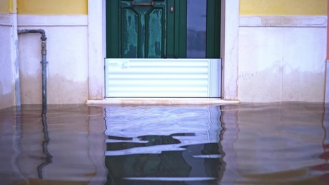Entrance door reflects in high tide waving flood water