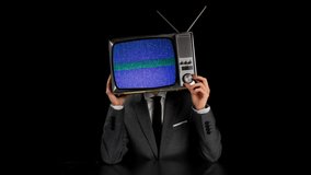 Man with a television as a head with glitch and distortion on the screen trying to tune into a channel