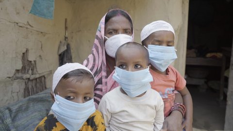 Champaran, Bihar, India, November 17 2020, In Champaran district of Bihar, A Poor Indian woman with her Children wearing face mask in Corona pandemic. High quality 4k footage