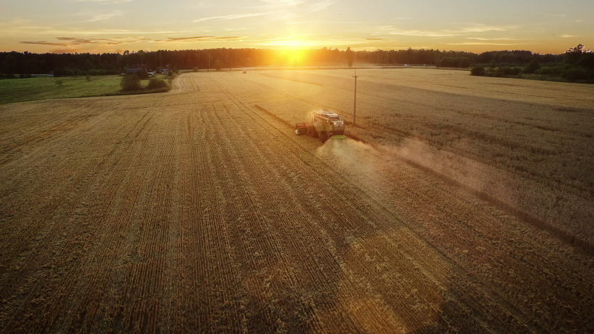 Aerial Shot: Harvester Working on Field. Digitalization of the Crops Growing Efficiency with AI Data Analysis Icons. Futuristic Agriculture Concept of Computerized, Eco, Sustainable way of Harvesting Royalty-Free Stock Footage #1064799127
