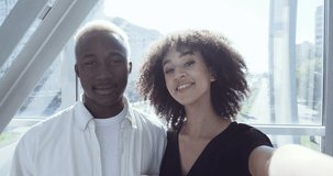 View from web camera ethnic couple young family african american girl with curls and black man holding tickets and passports waving to camera showing new city in background, travel vacation concept