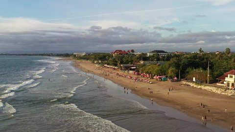 Aerial drone footage of the Kuta beach in Seminyak in south Bali in Indonesia. The beach its famous for its waves, surfing dramatic sunsets and beach bars. 