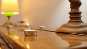 Lighting candles fire burning for party. small candle on wooden board. Close-up with traditional lamp in the background. Burning candle Wick from a candle in flame of fire. Symbol of happiness. - Powered by Shutterstock - Get 15% off with code: PIKWIZARD15