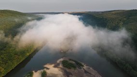 Flight through majestic foggy river Dnestr and lush green forest at sunrise time. Dniester canyon, Ukraine, Europe. Aerial UHD 4k drone video
