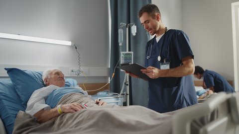 Hospital Ward: Friendly Male Nurse Talks with Elderly Patient Resting in Bed. Doctor Uses Tablet Computer, Does Checkup. Old Man Fully Recovering after Successful Surgery. Modern Bright Clinic