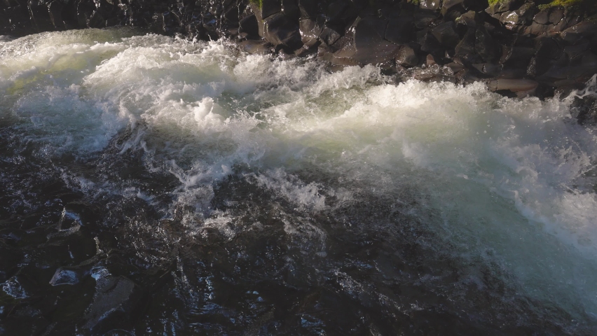 Fresh river water flowing down in a beautiful fresh rain forest during a sunny winter day. Slow Motion Taken in Brandywine Falls, near Whistler and Squamish, North of Vancouver, BC, Canada.