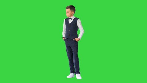Schoolboy in waistcoat and bow tie checking his watch, rolling eyes and sighing on a Green Screen, Chroma Key.