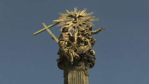 OLOMOUC, CZECH REPUBLIC, JUNE 29, 2020: Heritage plague column holy trinity UNESCO, statues of gilded gold copper Earth stand God the Father and Son, hovers Holy Spirit archangel Michael