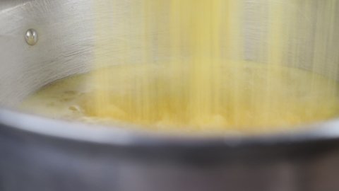 Putting yellow polenta in pot