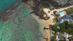 Luxury beach resort and the rocky. tropical coastline at Flic en Flac. in western Mauritius. from a drone perspective.