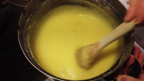 4k short video of the preparation of traditional polenta. Stir continuously for a long time on low heat.