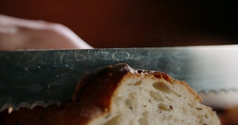 Close up shot of cutting fresh wheat bread with special knife. Preparation for breakfast or lunch. Food and drink concept 4k footage