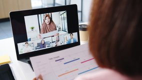 Young Asia businesswoman using laptop talk to colleague about plan in video call meeting while work from home at living room. Self-isolation, social distancing, quarantine for corona virus prevention. - Powered by Shutterstock - Get 15% off with code: PIKWIZARD15