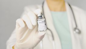 Slow motion of female doctor in white gown showing updates safe and effective mRNA Covid-19 Vaccine vial - The successful vaccination from COVAX collaborating. Hope, Partners, Pandemic, Action plan. - Powered by Shutterstock - Get 15% off with code: PIKWIZARD15