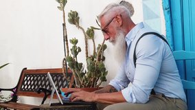 Senior hipster man working on a laptop, happiness, technology and elderly lifestyle people concept