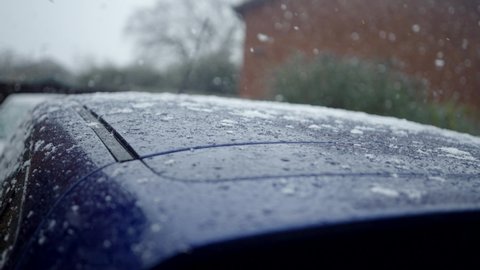 Snow flakes begin to fall on car roof in slow motion.

Filmed at 4K 120fps.