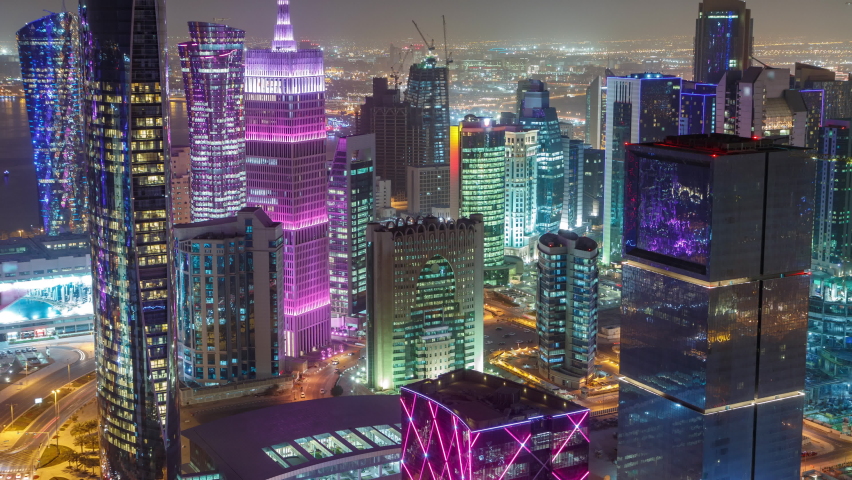 The skyline of the West Bay area from top in Doha timelapse, Qatar. Illuminated modern skyscrapers aerial view from rooftop at night. Traffic on the road Royalty-Free Stock Footage #1064886673