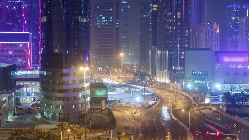 The skyline of the West Bay area and traffic from top in Doha timelapse, Qatar. Illuminated modern skyscrapers aerial view from rooftop at night