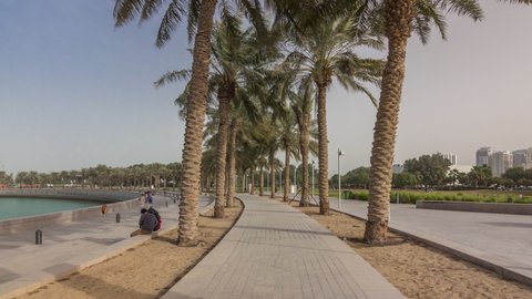 Walk in the MIA Park timelapse hyperlapse, located on one end of the seven kilometers long Corniche in the Qatari capital, Doha. Palms on both sides of path.